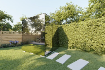 Reflective glass structure in a garden setting with greenery and a clear sky.