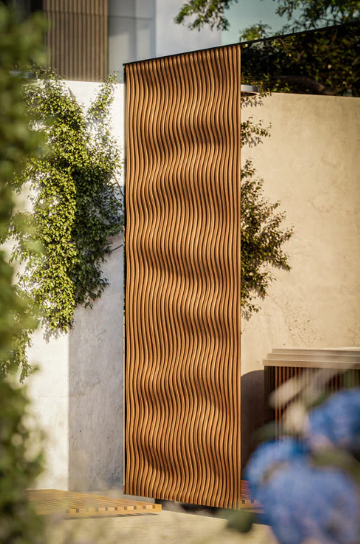 Textured brown panel on a building exterior with greenery around